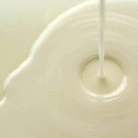 Axis-Y Dark Spot Correcting Glow Toner texture reference. The image shows a milky liquid that is being poured.